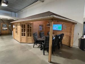 Tuindeco Jannie hoekblokhut 300x300 cm + zijluifel 275 cm - vuren blank incl. rode dakshingles (voorzijde), witte dakgoot en composiet funderingsbalken - excl. vlonder - Showmodel Amersfoort